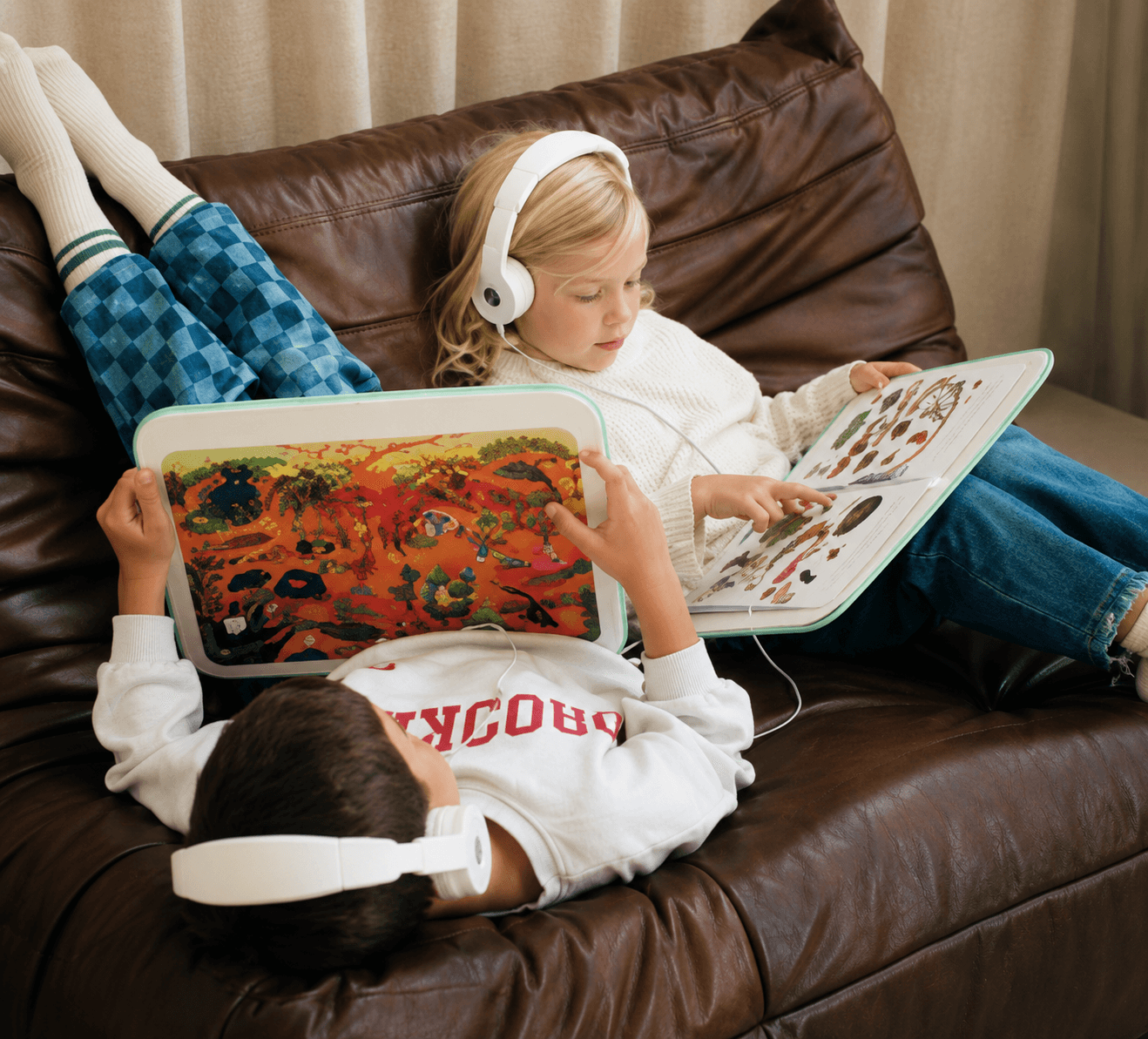 Niña leyendo con auriculares de diadema en un sillón
